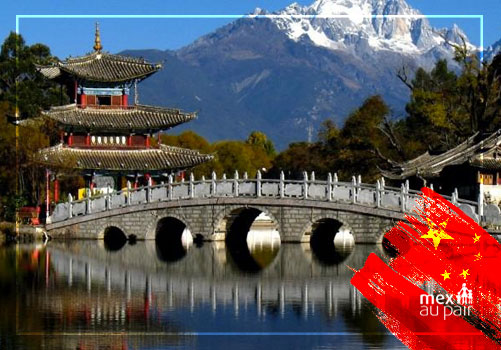 Paisaje de China con un puente tradicional y montañas nevadas