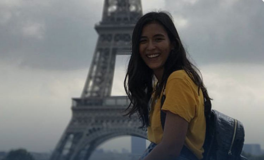 Au pair mexicana sonriendo frente a la Torre Eiffel en París